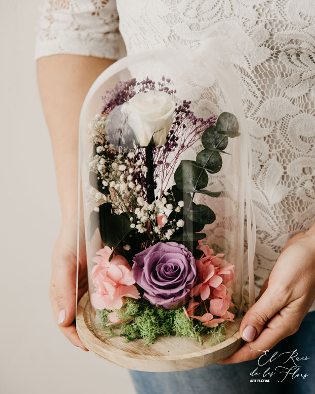 Juliette, rosas preservadas en lila y blanco, acompañado con verde y flores preservadas. Altura aproximada 25cm.