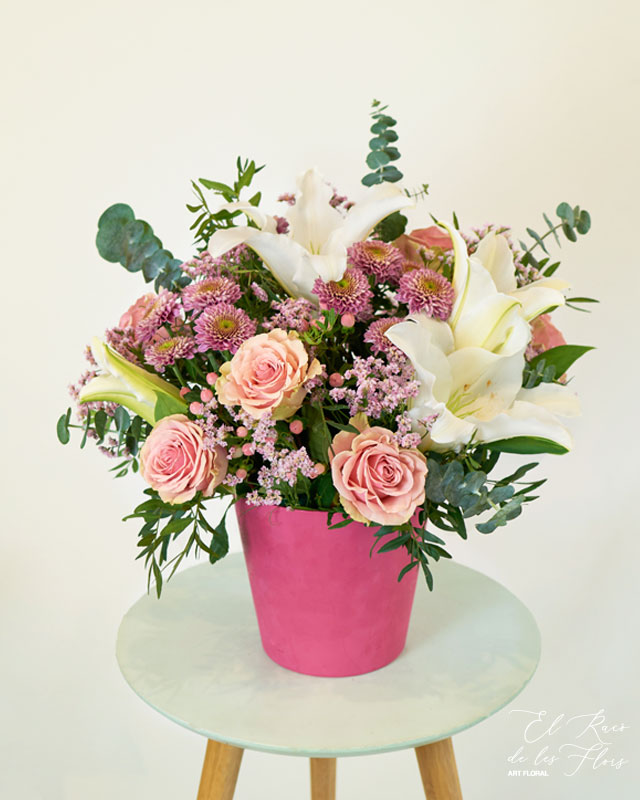 Margaret centro de flor fresca en tonos rosa y blanco. Compuesto por lilium oriental blanco, rosa rosa, crisantemo rosa, limonium, eucalipto usa, hipericum rosa y acabado con base decorativa.