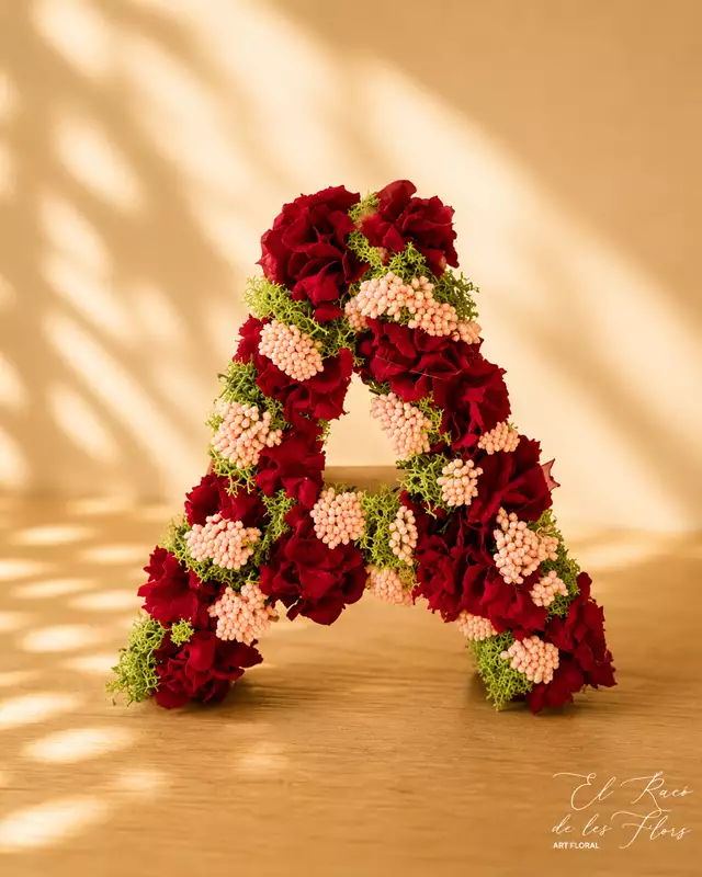 Letra A en flores secas y preservadas elaborada con Hortensia rojo, achillea rosa y musgo finlandés preservado verde.