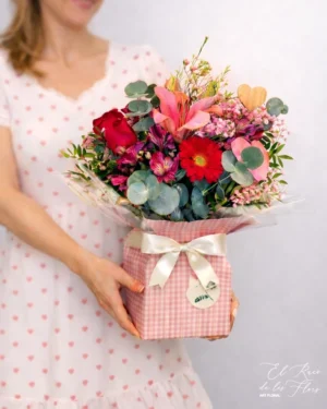 Bouquet de flores frescas en tonos rojo y rosa. Elaborado con dos rosas rojas, lilium, gerbera y astromelia. Caja de cartón con agua en el interior para que quede una acabado más completo y cómodo.
