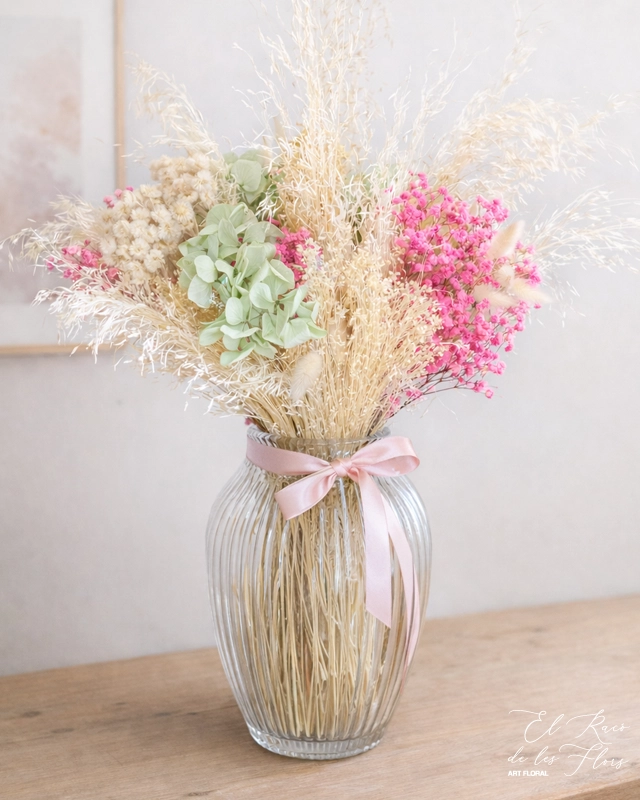 Jarrón de cristal con relieve Diamond y decorado con un bouquet En tonos blanco, rosa y verde mint. Materiales utilizados broom blanco, munni blanco, paniculata fucsia preservada, laugurus blanco.