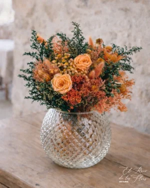 Original base en forma de pecera y relieve diamante, decorado con flores en tonos naranja y verde oscuro. Con dos rositas preservadas naranja . Materiales utilizados solidalgo, broom, laugurus, flor d arroz, rosa. Medidas bola 18cm x 18cm Medida diámetro ramo 29cm Altura total 33cm