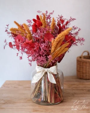 Jarrón de cristal con hojas de eucalipto en la base y decorado con un ramo de flores secas en tonos otoñales. Materiales utilizados phalaris rojo, eucalipto preservado rojo, limonium rojo, laugurus ocre. Medidas aprox Altura total 43cm x 18cm ancho