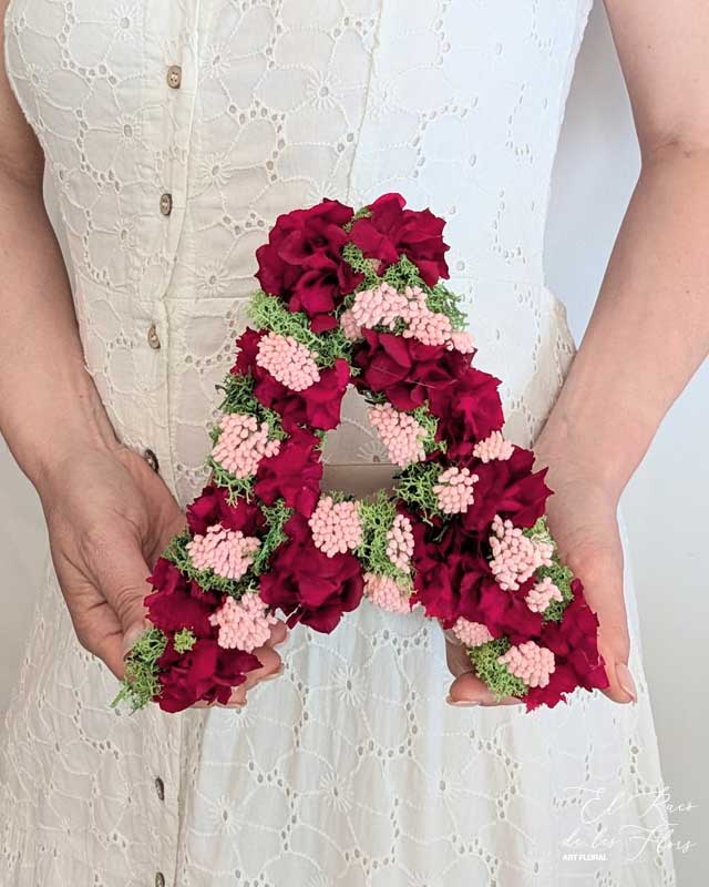 Letra A en flores secas y preservadas elaborada con Hortensia rojo, achillea rosa y musgo finlandés preservado verde.