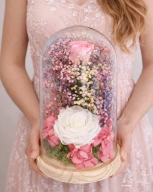 Una rosa preservada verde mint claro y otra verde turquesa. Acompañadas con paniculata preservada arcoiris y Hortensia