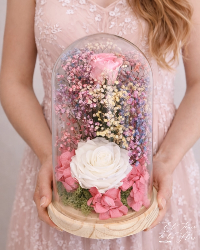 Una rosa preservada verde mint claro y otra verde turquesa. Acompañadas con paniculata preservada arcoiris y Hortensia