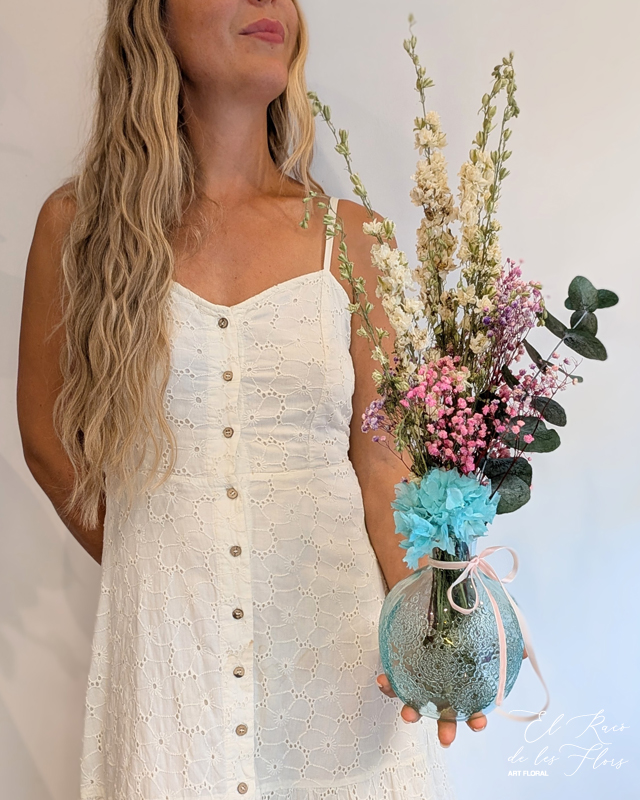 Jarrón bola en cristal turquesa gravado, estilo vintage. Decorado con hortensia turquesa preservada, paniculata lila y fucsia preservada, dephinium blanco preservado, y una ramita de eucalipto preservado. Medidas jarrón 13cm diámetro bola x 17cm altura. Trabajo floral altura total 56cm