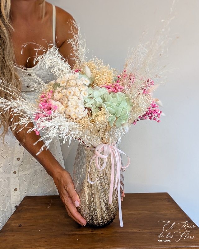 Jarrón de cristal con relieve Diamond y decorado con un bouquet En tonos blanco, rosa y verde mint. Materiales utilizados broom blanco, munni blanco, paniculata fucsia preservada, laugurus blanco.