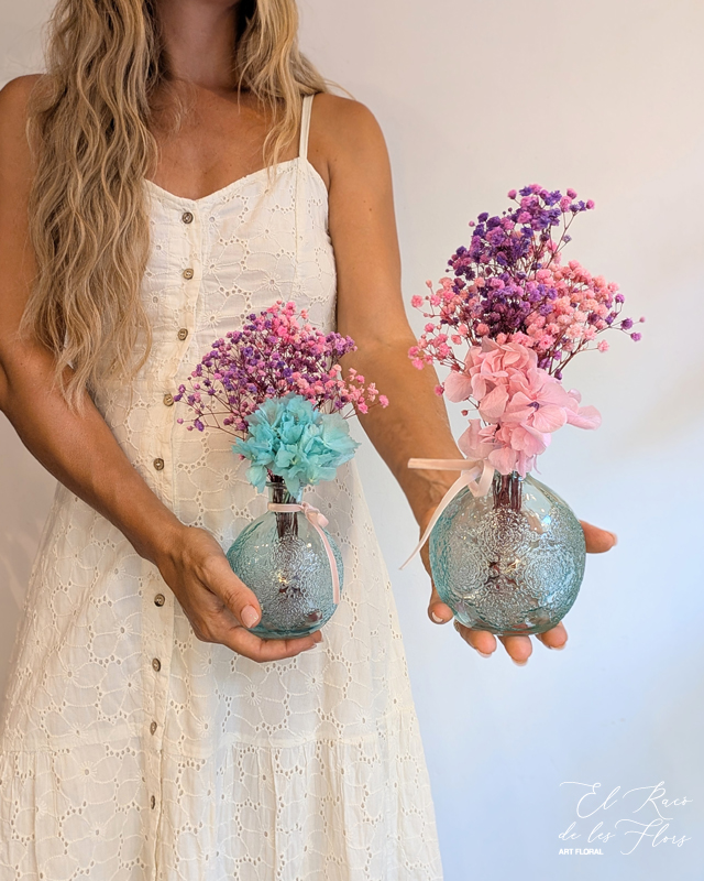 Jarrones bola en cristal turquesa gravado, estilo vintage. A elegir entre el rosa o el azul. Material utilizado: paniculata fucsia y paniculata lila. Hortensia turquesa. Todo preservado. Mismo con la hortensia en rosa. Medidas jarrón 9cm diámetro bola x 11,5cm altura. Medida total floral 30cm altura