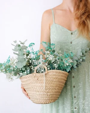 Ginevra, cesta de mimbre de tamaño pequeño compuesta por paniculata natural blanca, paniculata natural azul celeste y eucalipto natural seco. Medidas totales 33cm trabajo floral de ancho x 20cm ancho x altura 25cm