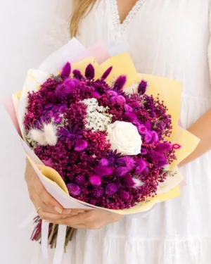 Bouquet de flores secas en tonos fucsia y rosa blanca preservada.